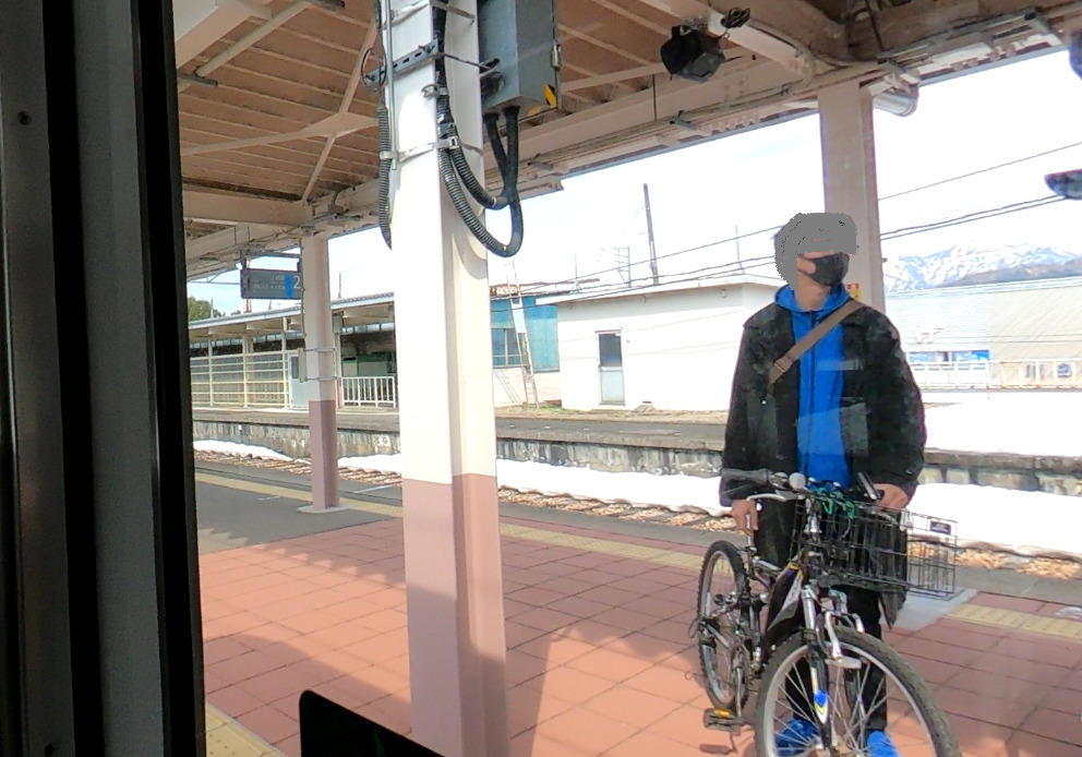 自転車と共に電車を待つ少年